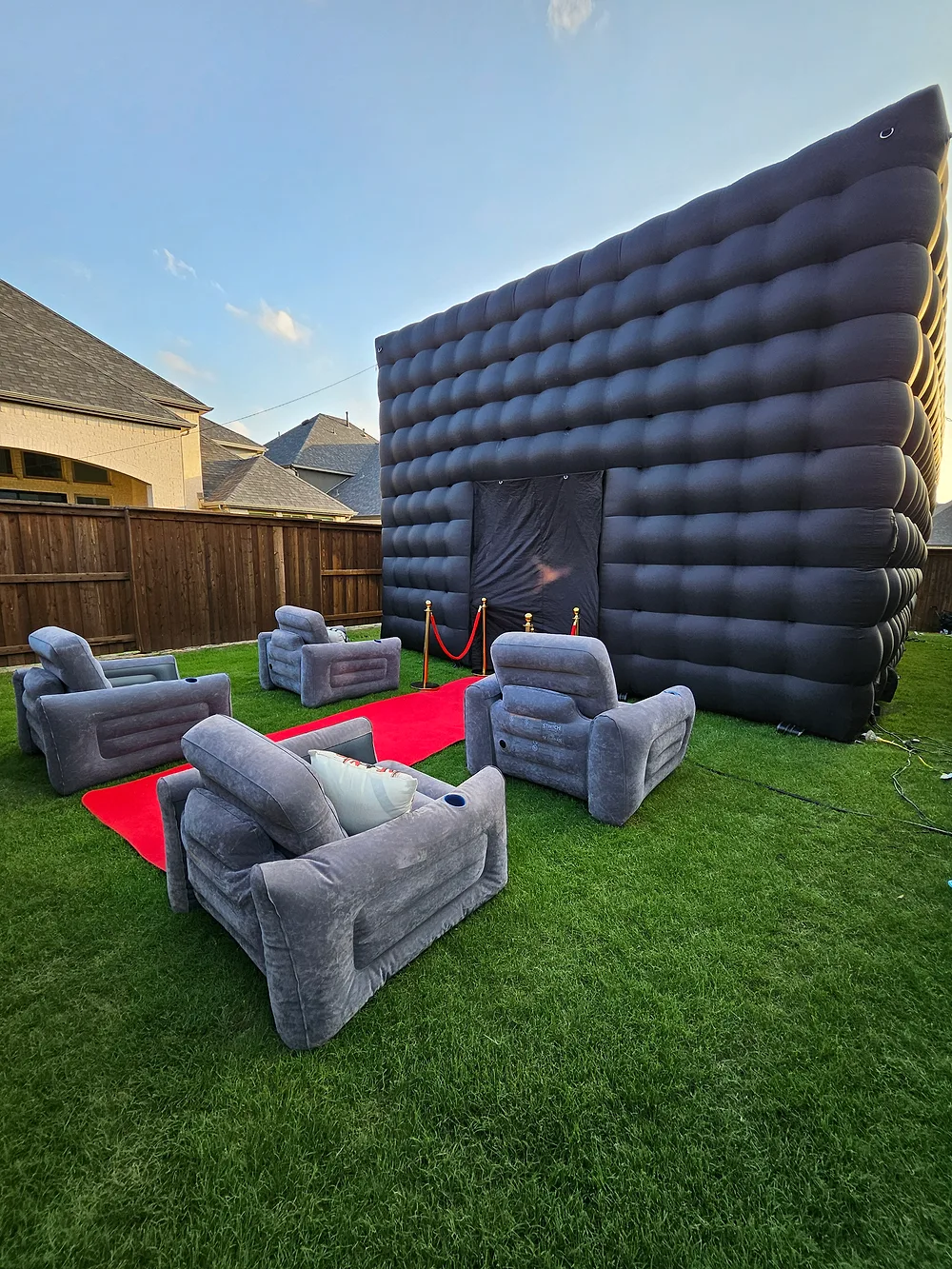Outdoor inflatable theater setup with lounge seating and red carpet — Backyard Movie Theater